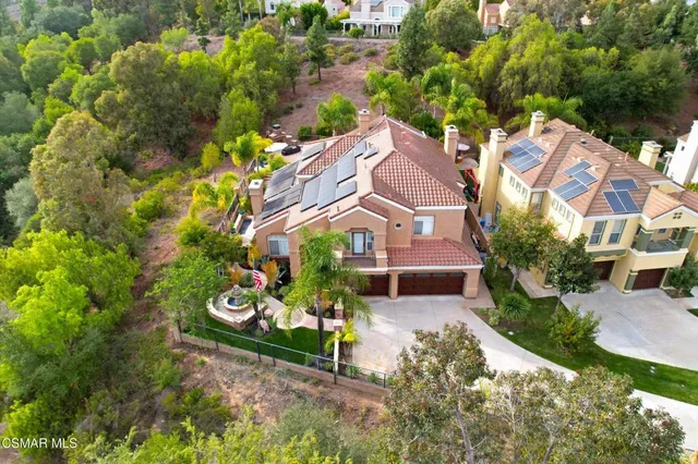an aerial view of residential houses with outdoor space and parking