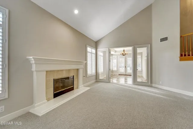 a view of an empty room with a fireplace and a window
