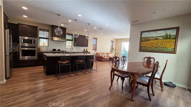 a view of a dining room with furniture wooden floor and kitchen