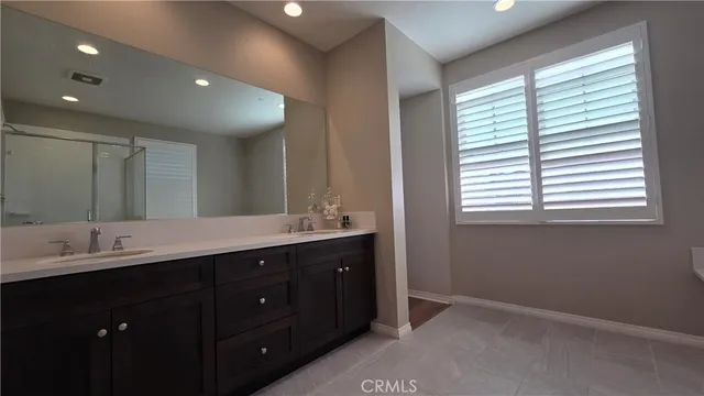 a bathroom with a double vanity sink and a mirror