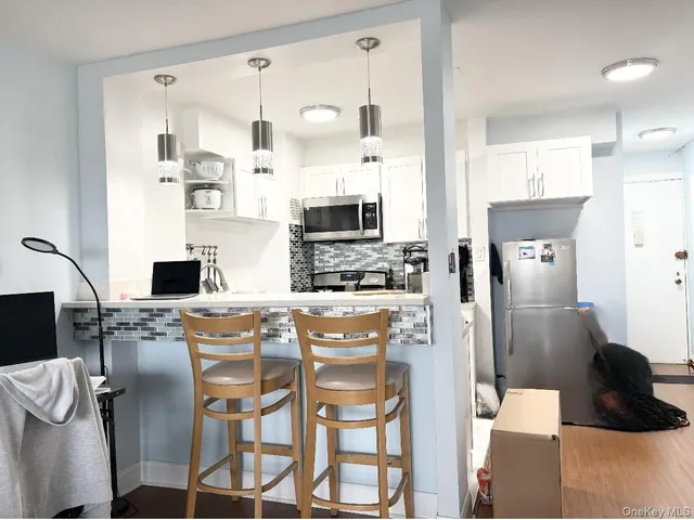 a kitchen with stainless steel appliances kitchen island granite countertop a refrigerator and microwave