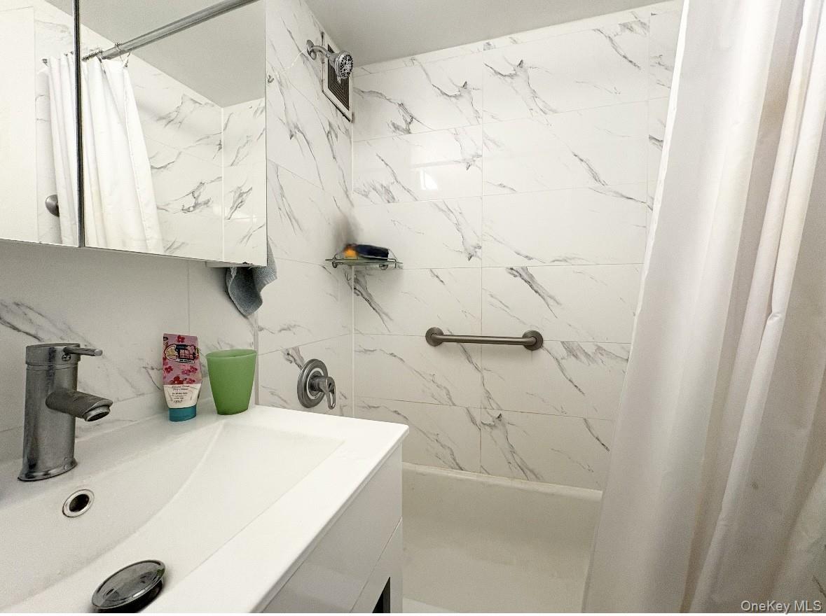 61-15 97th Street, Unit 15P Queens, NY 11374 - Photo 5 of 18 a bathroom with a sink and a shower