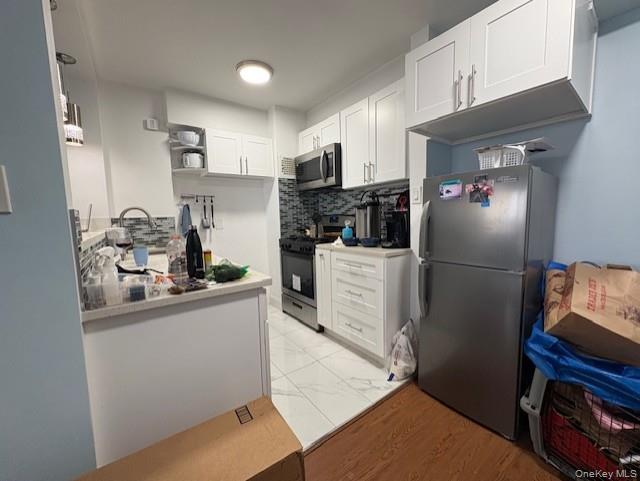 61-15 97th Street, Unit 15P Queens, NY 11374 - Photo 6 of 18 a kitchen with stainless steel appliances a refrigerator a sink a stove and cabinets