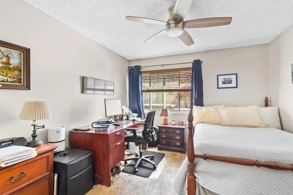 a bedroom with a bed a desk and chair with a bookshelf