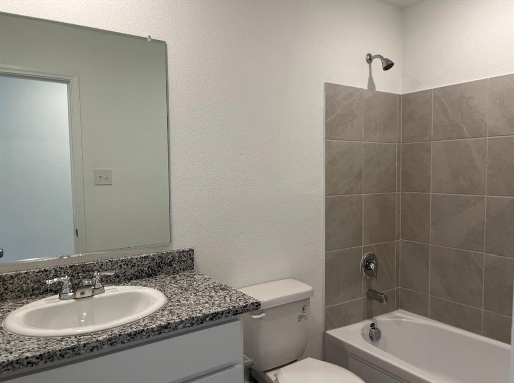 252 Jethro Lane Princeton, TX 75407 - Photo 12 of 20 a bathroom with a granite countertop sink a toilet and bathtub