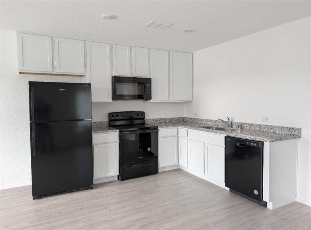 252 Jethro Lane Princeton, TX 75407 - Photo 4 of 20 a kitchen with a refrigerator stove and microwave