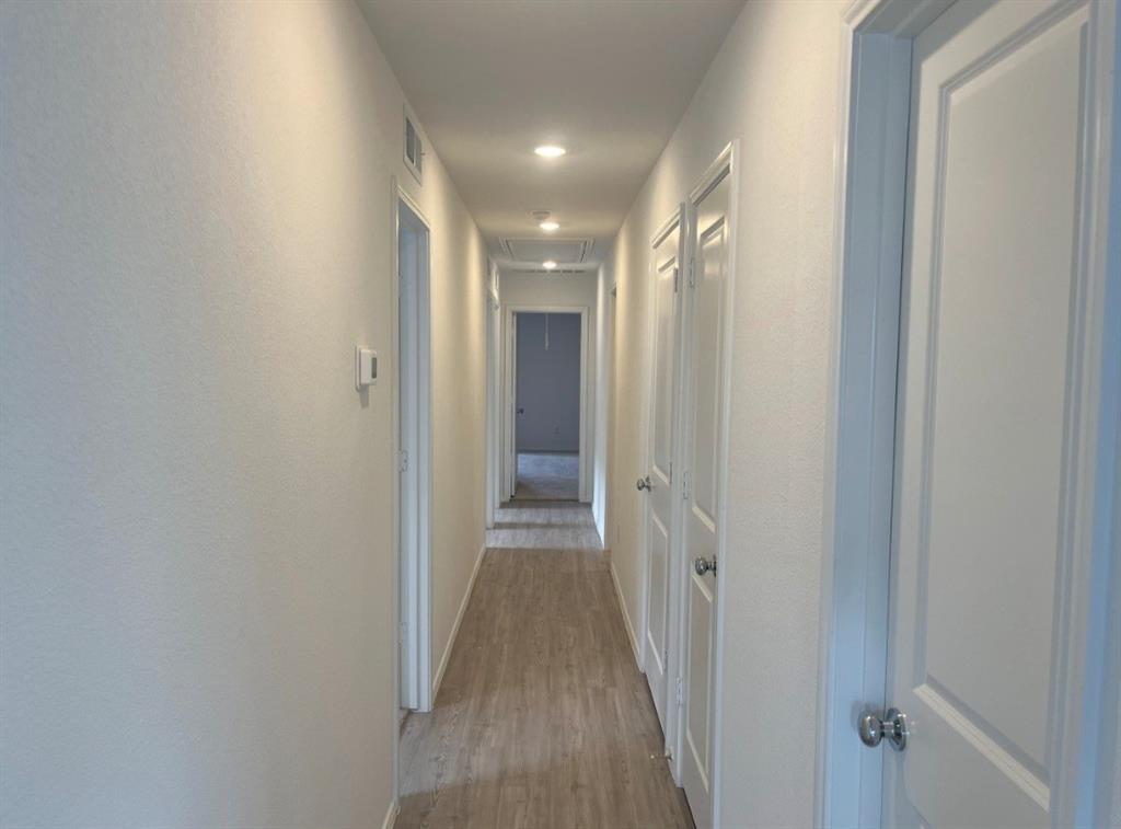 252 Jethro Lane Princeton, TX 75407 - Photo 7 of 20 a view of a hallway with wooden floor