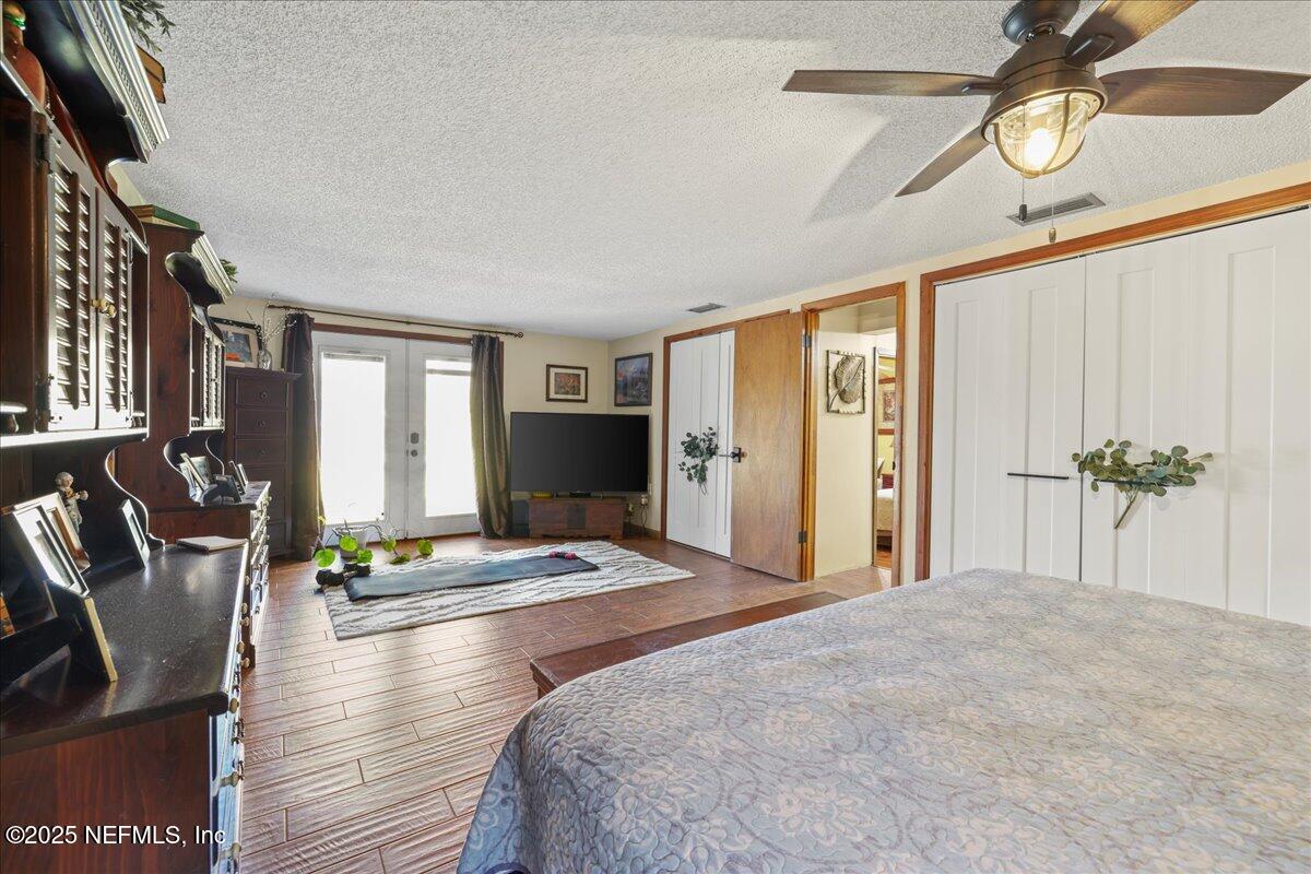 188 Palm Drive Georgetown, FL 32139 - Photo 27 of 47 a bedroom with a bed a chandelier and flat screen tv