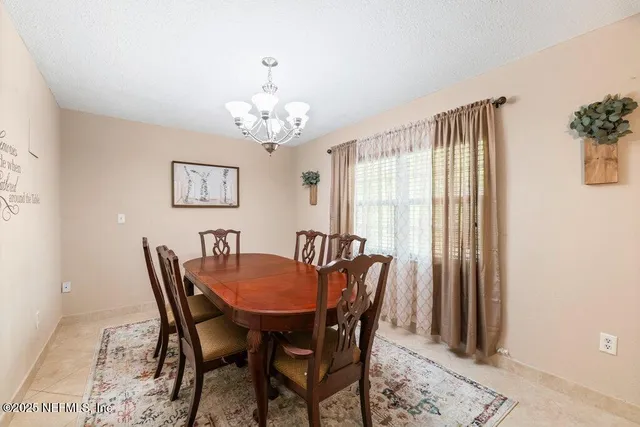 a view of a dining room with furniture and chandelier