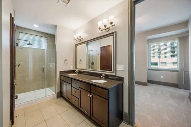 a spacious bathroom with a granite countertop sink a mirror and a shower