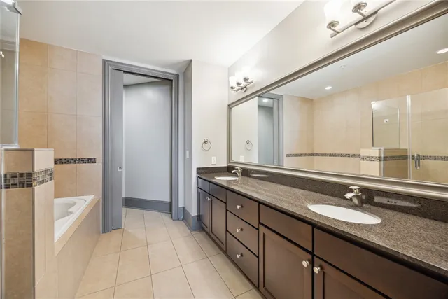 a spacious bathroom with a granite countertop sink a mirror and a shower