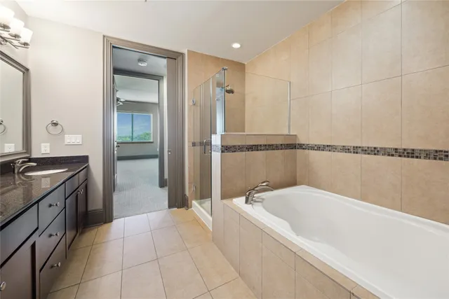 a spacious bathroom with a tub sink and mirror