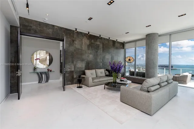 a living room with furniture and a floor to ceiling window