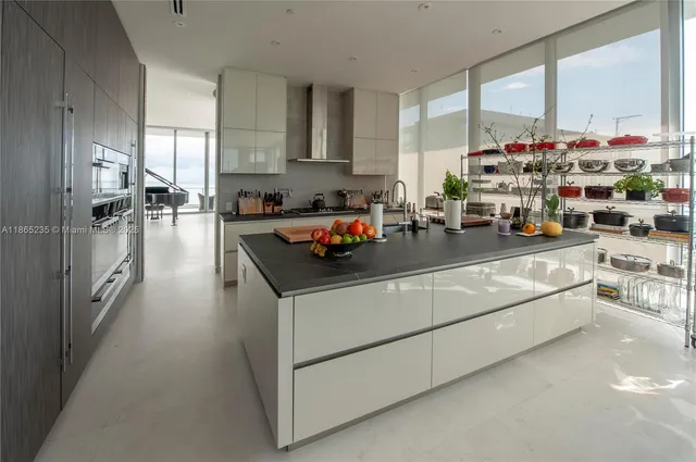 a living room with furniture large windows and a table