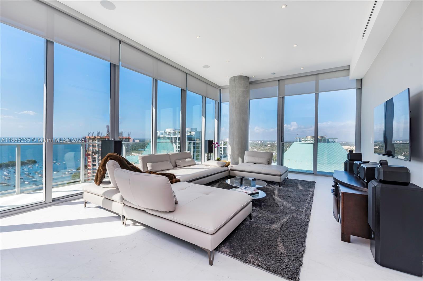 2669 South Bayshore Drive, Unit PH1N Coconut Grove, FL 33133 - Photo 24 of 39 a living room with furniture large windows and a table