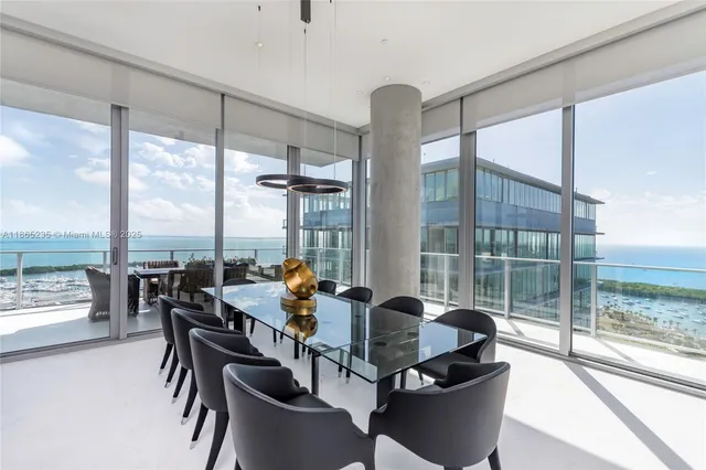 a dining room with furniture and floor to ceiling windows
