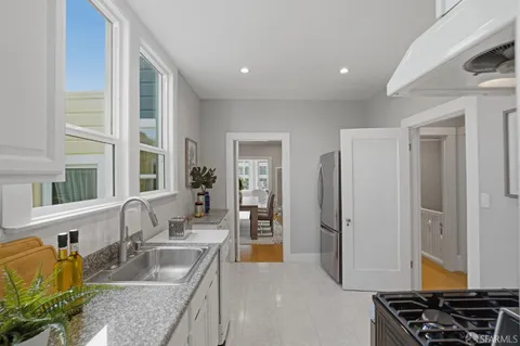 a kitchen with stainless steel appliances granite countertop a sink and a refrigerator