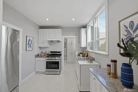 a kitchen with stainless steel appliances granite countertop a stove a sink and a refrigerator