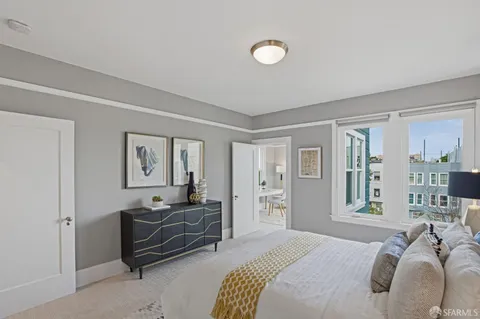 a bedroom with furniture and a large window