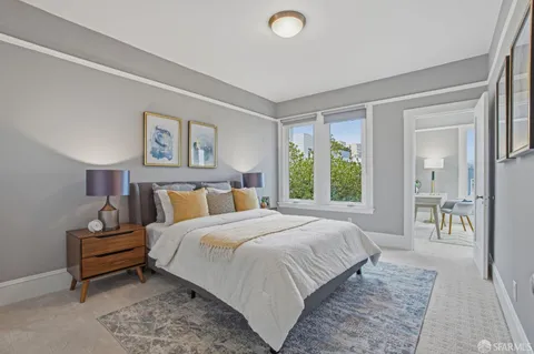 a bedroom with a bed and a large window