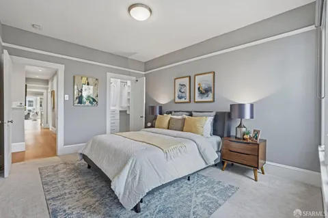 a bedroom with a bed and a lamp on dresser