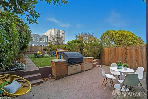 a patio with a table and chairs and potted plants