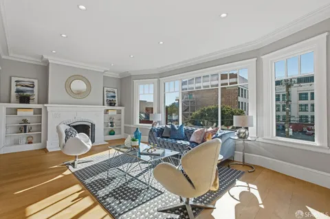 a living room with furniture a fireplace and a table