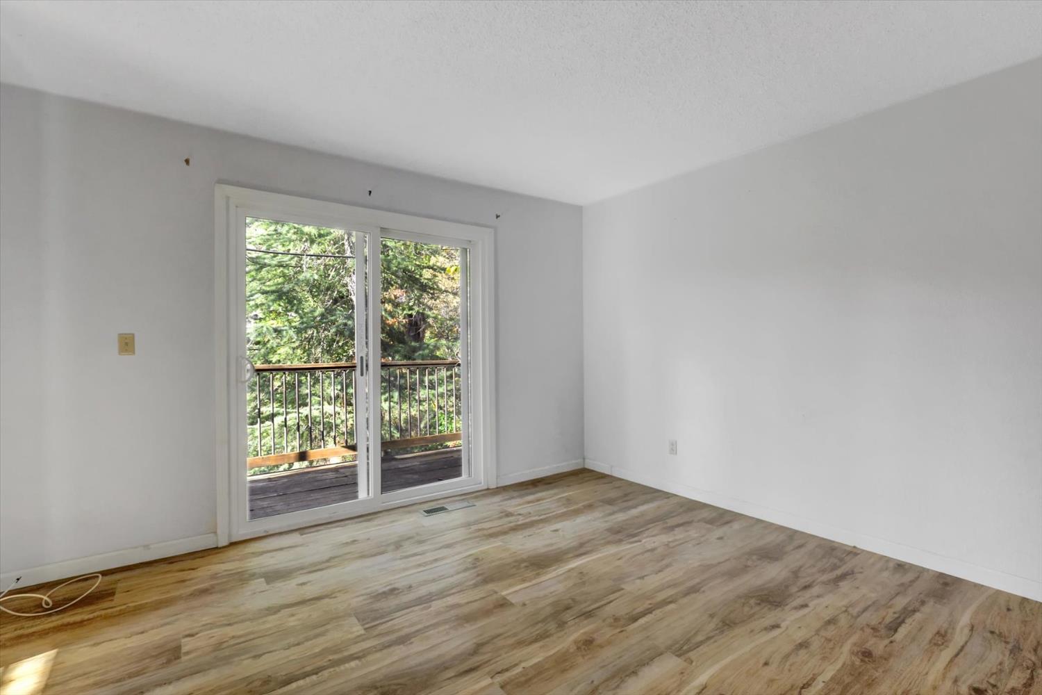 23126 Foothill Road Auburn, CA 95602 - Photo 35 of 63 a view of an empty room with wooden floor and a window