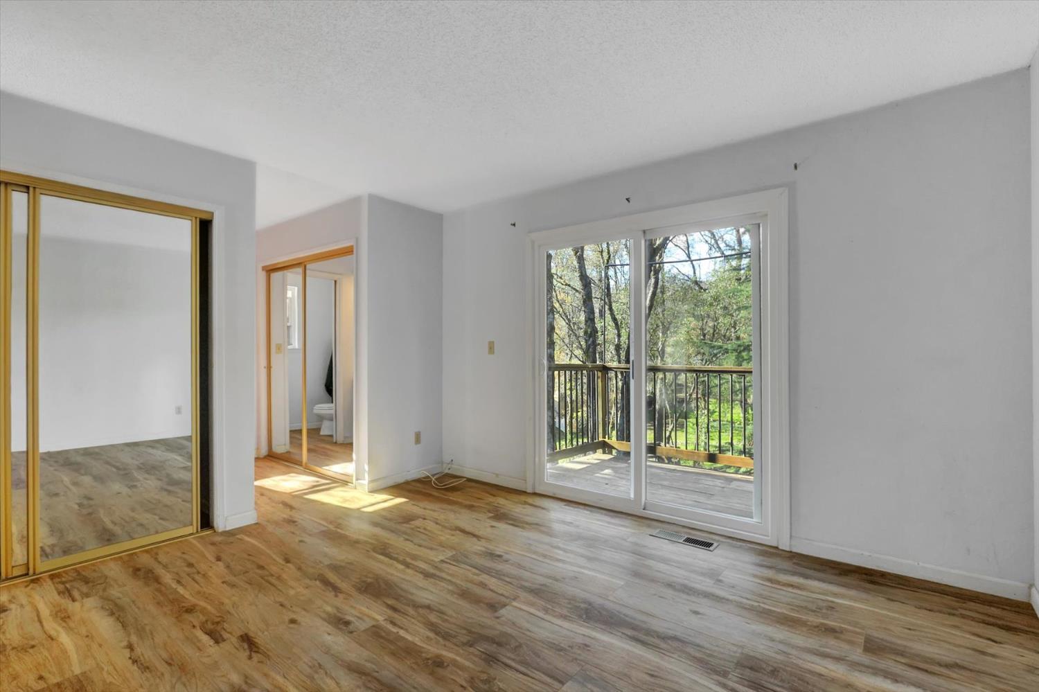 23126 Foothill Road Auburn, CA 95602 - Photo 36 of 63 a view of an empty room with wooden floor and a window