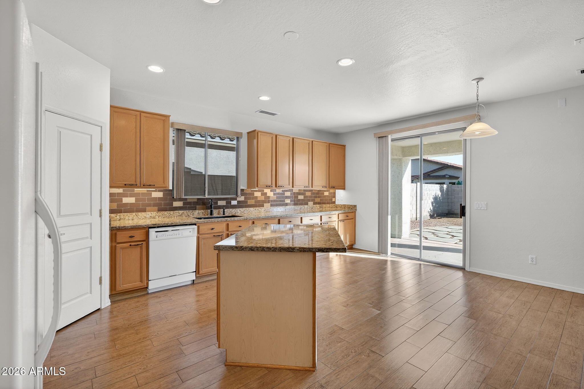 8217 West Bloomfield Road Peoria, AZ 85381 - Photo 13 of 48 a kitchen with stainless steel appliances granite countertop a refrigerator a sink dishwasher a stove and white cabinets with wooden floor