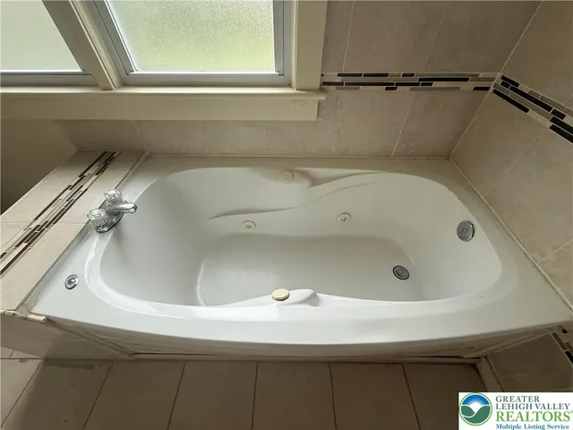 a bathroom with a tub and a window