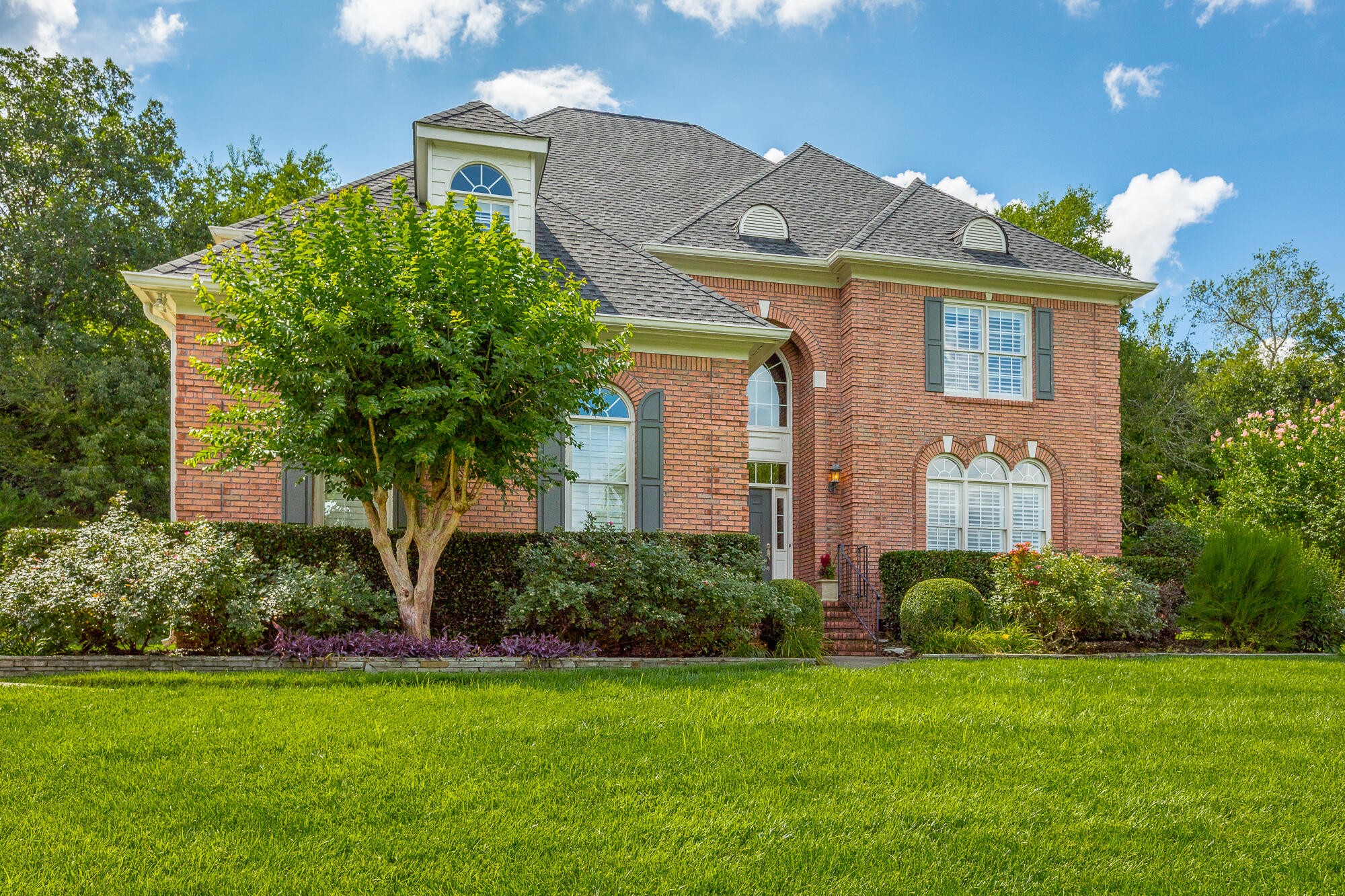 9619 Windrose Circle Chattanooga, TN 37421 - Photo 1 of 69 a front view of a house with a garden