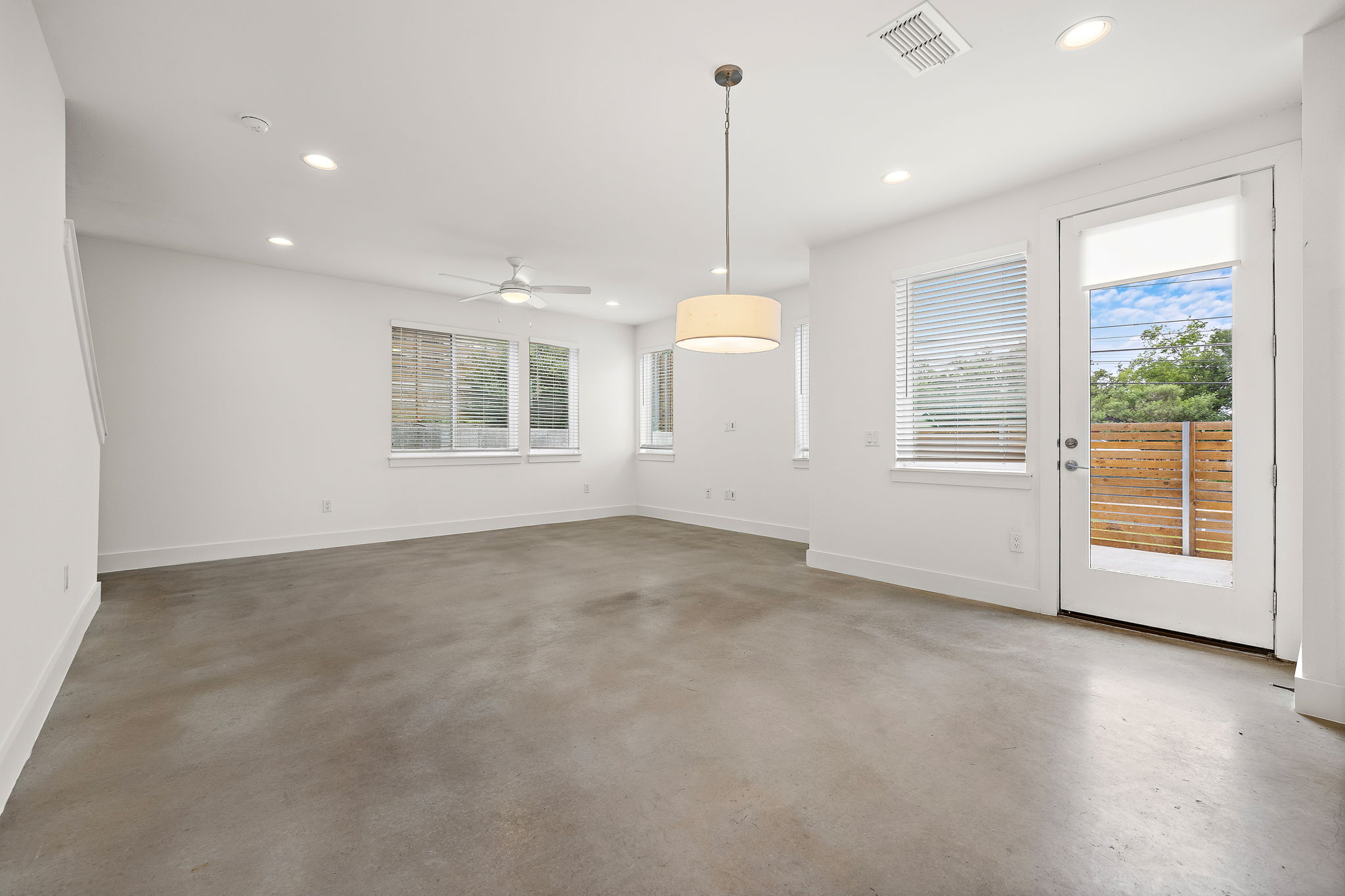 1206 Sarabeth Way Austin, TX 78721 - Photo 10 of 27 Unfurnished living room with ceiling fan, concrete flooring, and recessed lighting