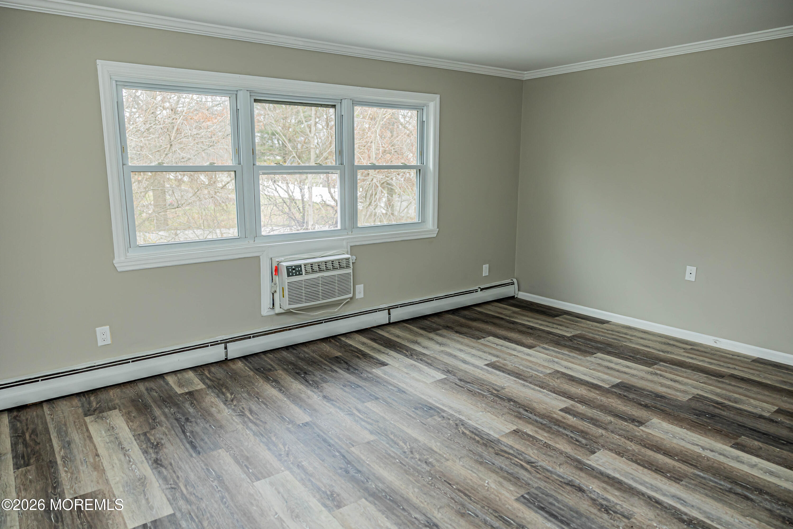 18 Windsor Terrace, Unit 18 Freehold, NJ 07728 - Photo 21 of 37 a view of an empty room with wooden floor and a window