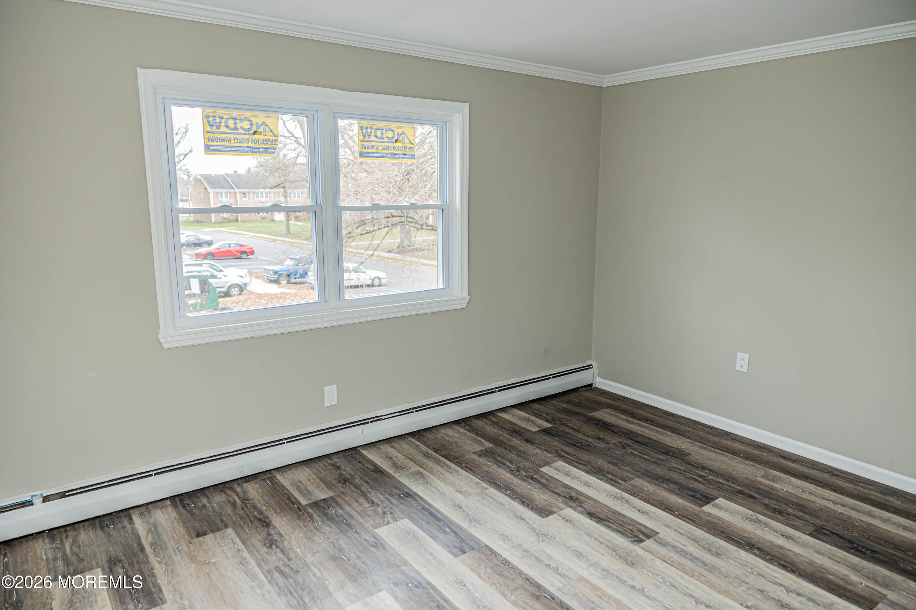 18 Windsor Terrace, Unit 18 Freehold, NJ 07728 - Photo 22 of 37 a view of an empty room with wooden floor and a window