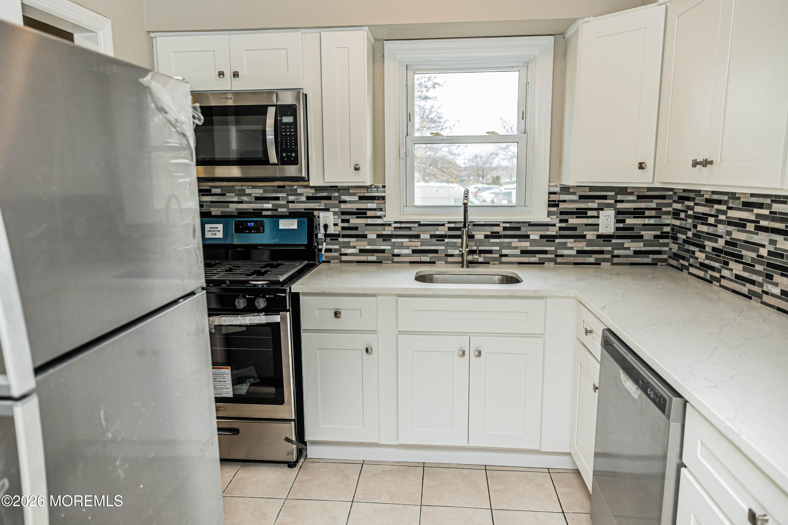 18 Windsor Terrace, Unit 18 Freehold, NJ 07728 - Photo 4 of 37 a kitchen with stainless steel appliances a sink stove and microwave