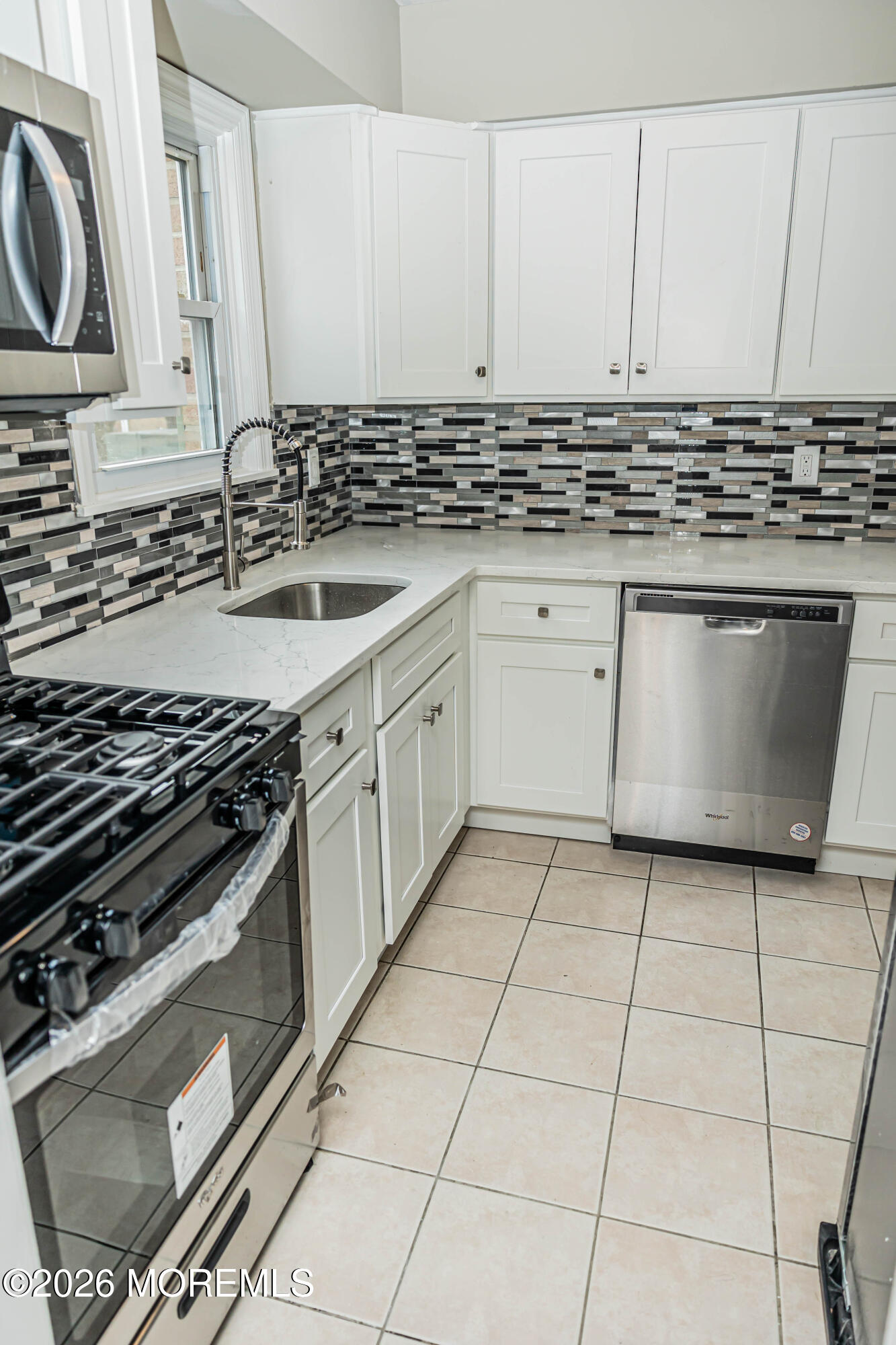 18 Windsor Terrace, Unit 18 Freehold, NJ 07728 - Photo 5 of 37 a kitchen with a stove a sink and a microwave