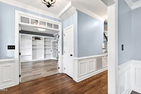 a view of a hallway with wooden floor and staircase
