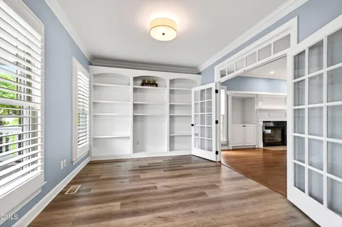 a kitchen with wooden floors and white cabinets