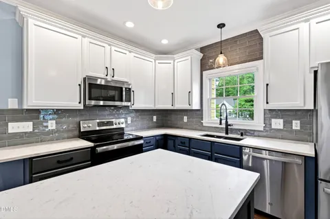 a kitchen with stainless steel appliances a stove sink microwave and cabinets