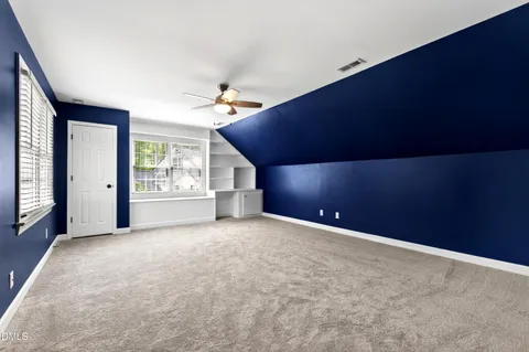 a view of a backyard with wooden fence and a bench