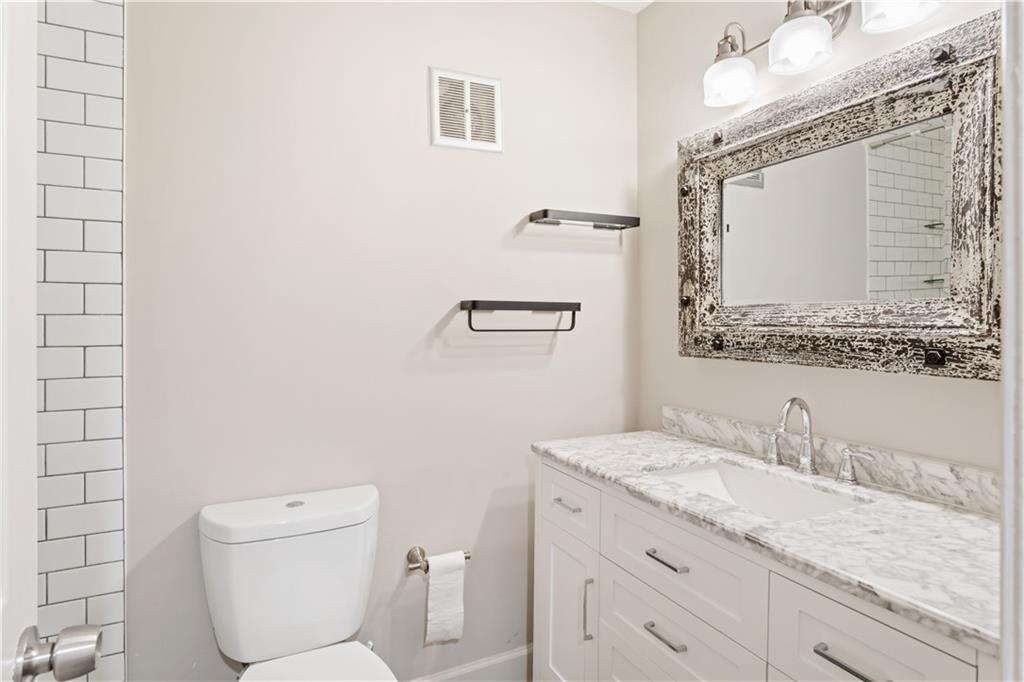 6700 Roswell Road, Unit 23A Atlanta, GA 30328 - Photo 14 of 18 a bathroom with a granite countertop toilet sink and mirror