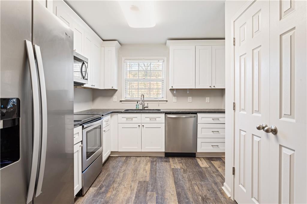 6700 Roswell Road, Unit 23A Atlanta, GA 30328 - Photo 5 of 18 a kitchen with granite countertop a refrigerator stove top oven and sink