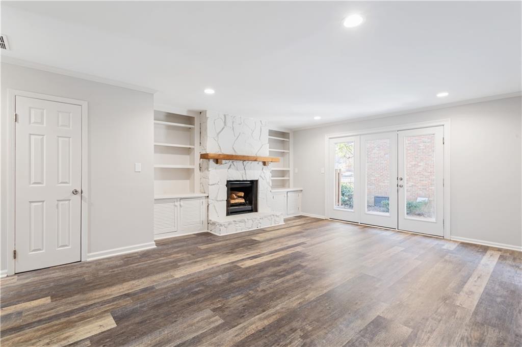 6700 Roswell Road, Unit 23A Atlanta, GA 30328 - Photo 6 of 18 a view of empty room with wooden floor and fireplace