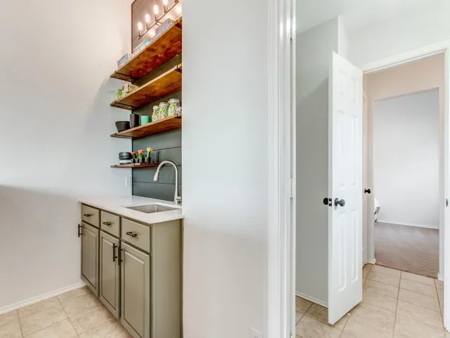 a hallway with a sink a mirror a vanity and a window