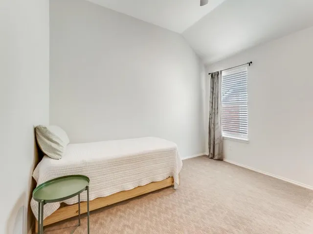 a bedroom with a bed a table and painting on the wall