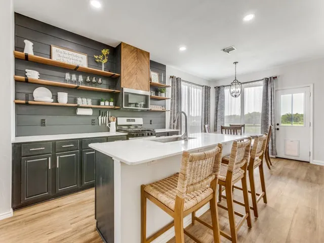 a kitchen with a sink and chairs