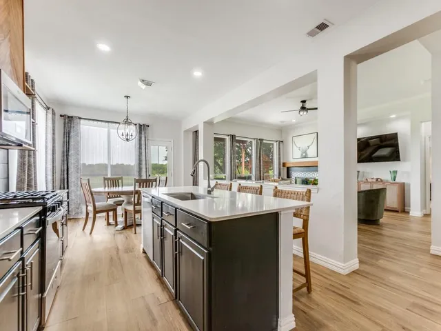 a kitchen with counter top space a sink appliances and cabinets