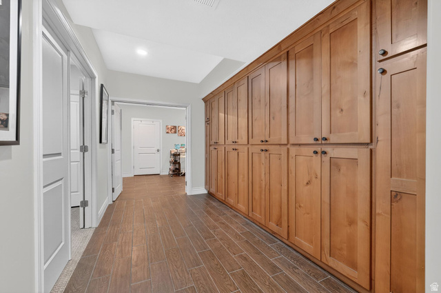 14738 Tangle Hill Road Herriman, UT 84096 - Photo 44 of 66 Extensive built-in wood cabinetry with black hardware, wood-finish tile flooring, recessed lighting, and crisp white trim
