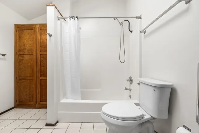 a bathroom with a shower a toilet and a shower